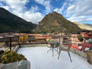 a balcony with a table and chairs and a mountain at intikilla hostal in Ollantaytambo