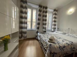 a bedroom with a bed and two windows at Priamar house in Savona