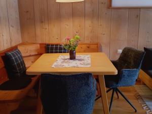 a table with chairs and a vase with flowers on it at Haiderhof in Schleching +14 photos