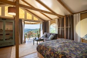 a bedroom with a bed and a couch and a table at Glamping Stregaia in Massa Marittima