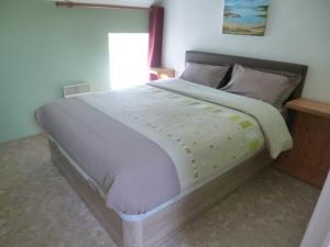 a bedroom with a large bed with white sheets at Gîte des Oiseaux in Bieuzy-les Eaux