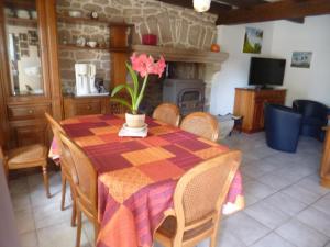 a dining room with a table with a flower on it at Gîte des Oiseaux in Bieuzy-les Eaux