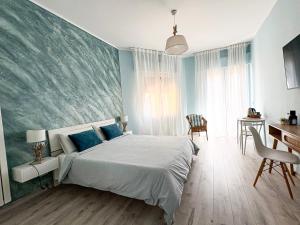 a bedroom with a large bed with blue walls at Favola Guesthouse Affittacamere in Nettuno