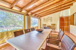 a dining room with a table and chairs and a large window at Finca Cas Padrins in Manacor