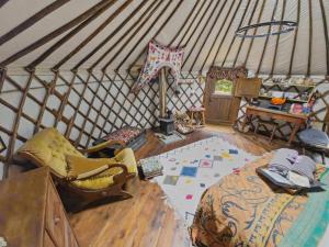 a room with a yurt with a bed and a table at Esk Yurt in Drummelzier