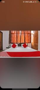 a bedroom with a bed with red pillows at Hotel Manali Villa in Manāli