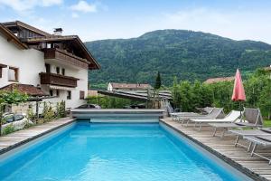 a swimming pool next to a building with a mountain at Residence Sonngart in Lagundo