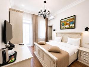 a bedroom with a large bed with a desk and a tv at Aspar Boutique Hotel in Yerevan