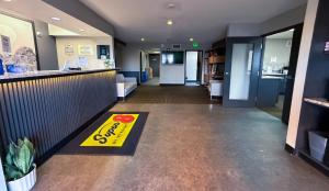 a restaurant lobby with a yellow sign on the floor at Super 8 by Wyndham Windsor in Windsor
