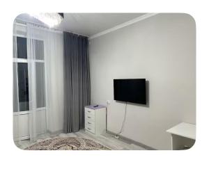a white room with a tv on a wall at Fly Apart in (( Turksib ))