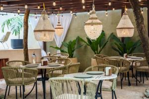 a restaurant with tables and chairs and chandeliers at Terasu Riviera Maya Hotel & Spa, en Xcaret in Playa del Carmen