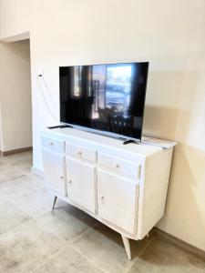 a flat screen tv on top of a white dresser at Deluxe Nueva Casa in General Alvear