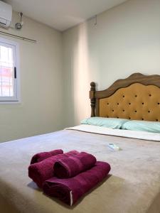 a bedroom with a bed with purple towels on it at Deluxe Nueva Casa in General Alvear +1 photo
