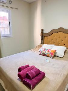 a bed with two purple towels on top of it at Deluxe Nueva Casa in General Alvear
