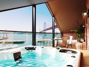 eine Badewanne in einem Zimmer mit Blick auf die Brücke in der Unterkunft Docas Hotel Lisbon in Lissabon