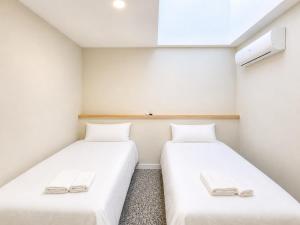 two beds in a small room with white walls at Hostal Majadahonda in Majadahonda