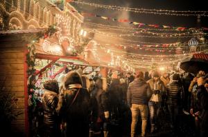 a crowd of people walking through a christmas market at Garner Hotel Friedrichshafen by IHG in Friedrichshafen