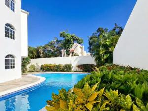 ein Swimmingpool vor einem Haus in der Unterkunft Costambar in San Felipe de Puerto Plata