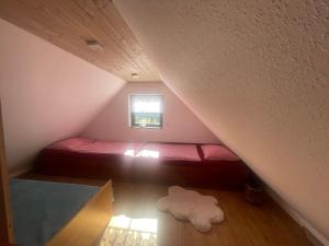 a small bedroom with a red bed in a attic at Novoveská chaloupka in Stříbrná