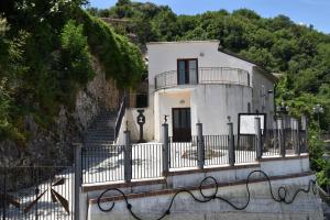 a white house with a fence and stairs at Ostello della Gioventù Massimo Troisi in Oliveto Citra