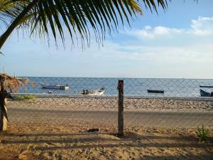 a fence on a beach with boats in the water at Cabana Coral Reef in Mandapam +3 photos