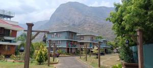 a view of a town with a mountain in the background at Mountain Meadows Resort in Kollengode