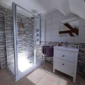 a bathroom with a glass shower and a sink at Chambre d'hôtes Chez Sarah in Saint-Bon