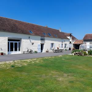 a white building with a lawn in front of it at Chambre d'hôtes Chez Sarah in Saint-Bon