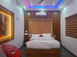 a bedroom with a bed and a red chair at Mountain Meadows Resort in Kollengode