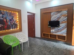 a waiting room with two chairs and a tv at Mountain Meadows Resort in Kollengode