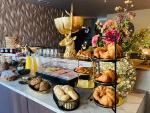 a buffet with various types of bread and pastries at De La Frontière Bed & Borrelbistro in Slenaken +42 photos