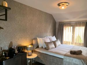 a bedroom with a large bed and a window at De La Frontière Bed & Borrelbistro in Slenaken