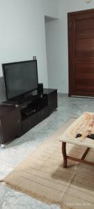 a living room with a flat screen tv and a table at Appartement 24 in Sousse