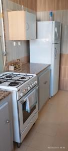 a kitchen with a stove and a refrigerator at Appartement 24 in Sousse