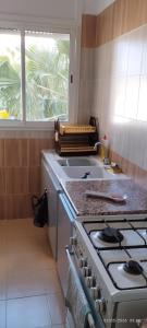 a kitchen with a stove and a sink and a window at Appartement 24 in Sousse +25 photos