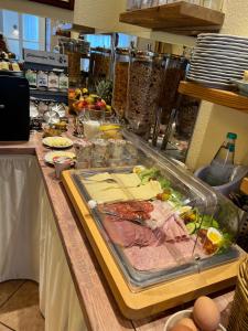 a buffet with meat and other foods on a table at Pension Lüttje Meermaid in Borkum