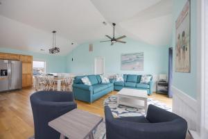 a living room with blue couches and a table at 5319 - Day Dreamz in Kill Devil Hills