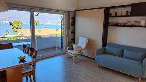 a living room with a blue couch and a table at La terrazza sul Lago Maggiore in Brezzo