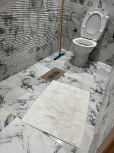 a bathroom with a toilet and a towel on the floor at Résidence Meublée Jihane in Laayoune +37 photos