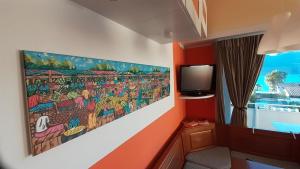 a room with a painting on the wall and a tv at La terrazza sul Lago Maggiore in Brezzo