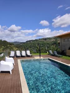 a swimming pool with lounge chairs next to a house at Quinta Da Porta Caseira in Resende