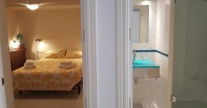 a bedroom with a bed and a bathroom with a sink at Calella-Port Bo · Sun Sea Unique Character in Calella de Palafrugell