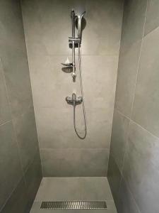 a shower with a shower head in a bathroom at Apartmán Bytča in Bytca