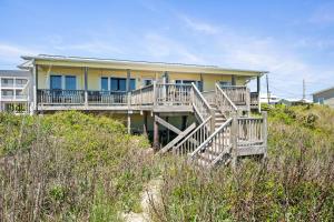 a house on top of a hill with a house at Paradise West by Emerald Isle Realty in Emerald Isle