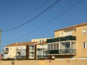 an apartment building with balconies and a blue sky at Au clair soleil in Frontignan