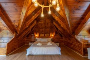 a bedroom with a bed in a wooden attic at KayakHotel in Ndërlisaj