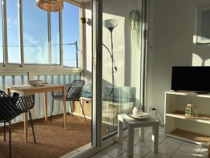 a living room with a balcony with a view of the ocean at Au clair soleil in Frontignan