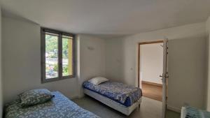 a bedroom with two beds and a window at L'auberge le Toit Vert in Moutiers