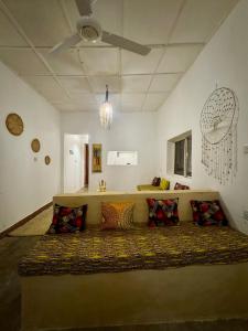 a room with a large bed with pillows in it at Beach House in Jambiani