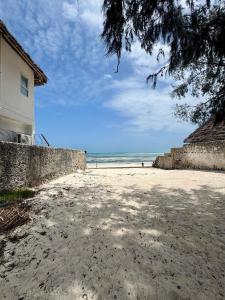 a sandy beach with a building and the ocean at Beach House in Jambiani